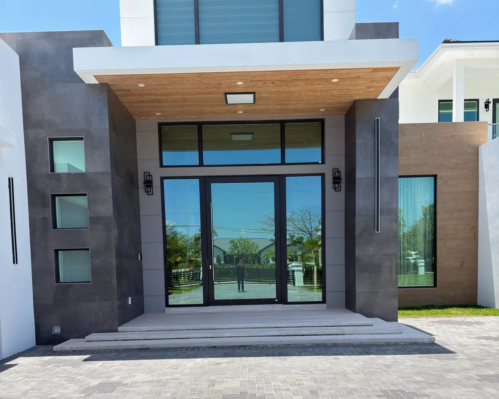 Main facade in daylight, with grey panels and a glazed double door
