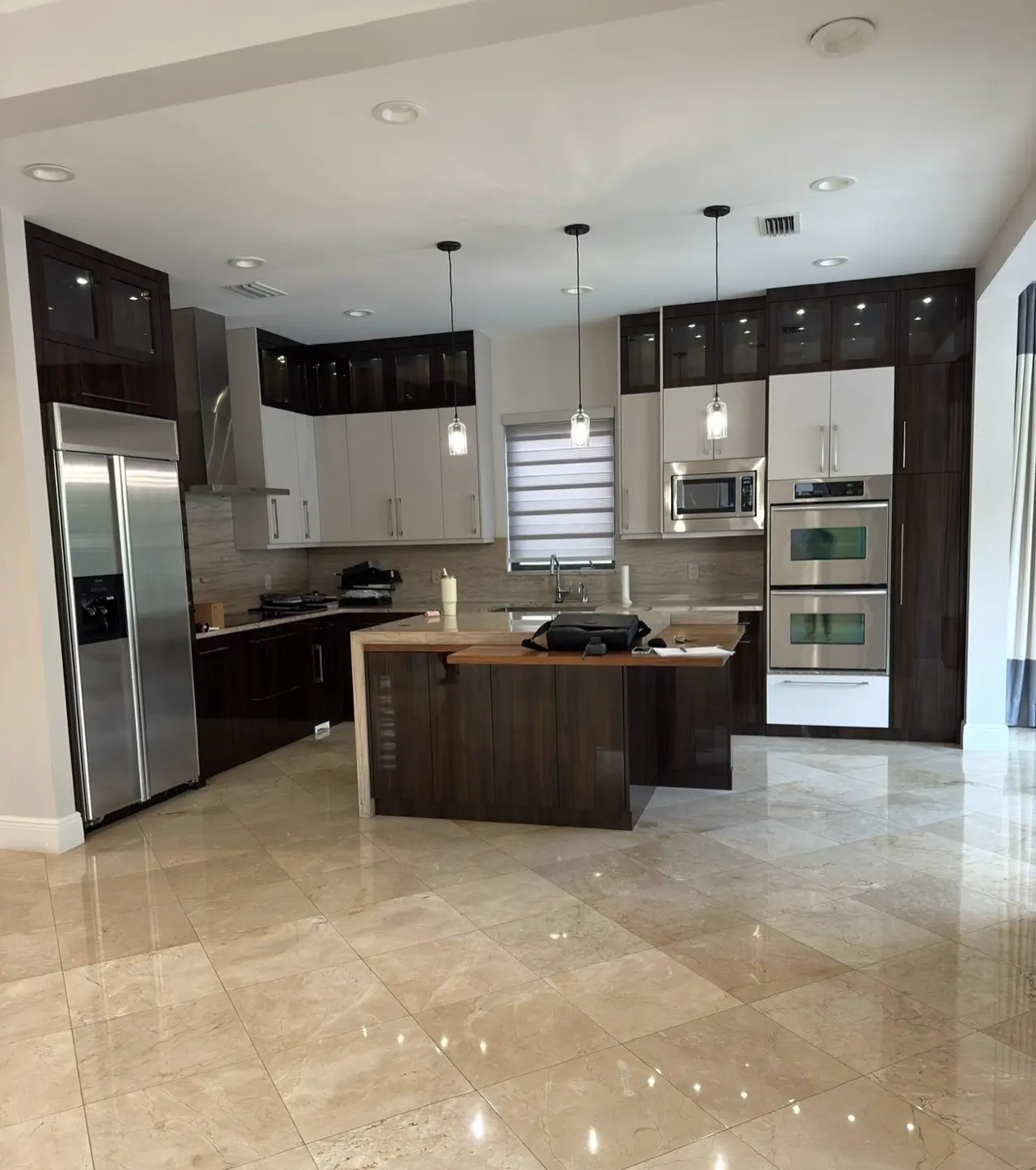 Kitchen with dark wood cabinets, a small island and stainless appliances
